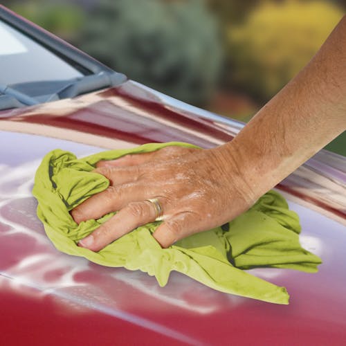 Microfiber cloth being used to wipe down the surface of a car.